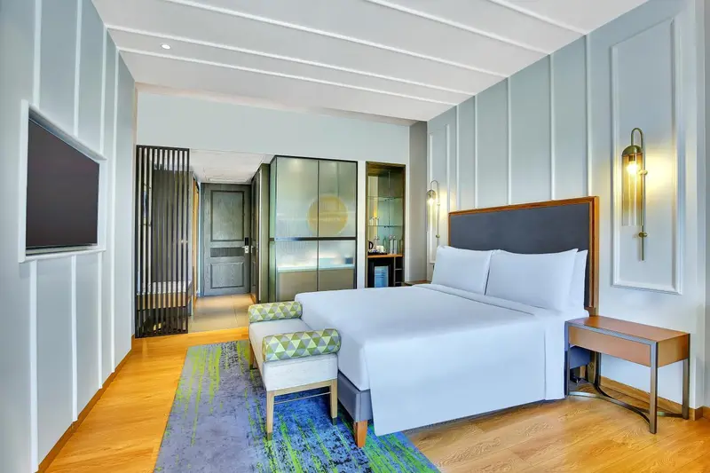 Une chambre lumineuse avec un grand lit et un espace détente.