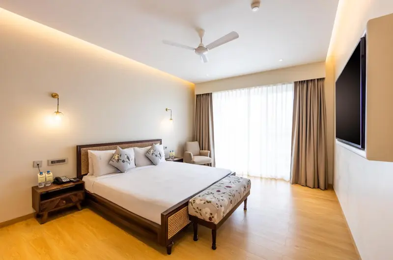 Une chambre lumineuse avec un grand lit et un coin salon.