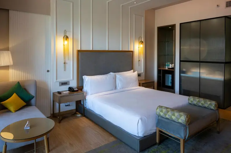 Une chambre lumineuse avec un grand lit et un coin salon.