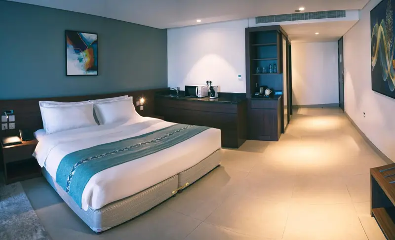 Une chambre lumineuse avec un grand lit et un espace détente.