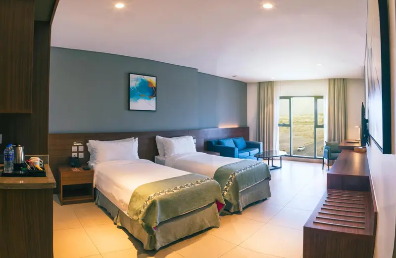 Une chambre lumineuse avec un grand lit et un coin salon.