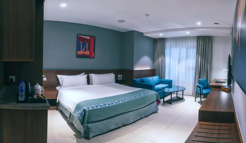Chambre d'hôtel moderne avec un lit double et un coin salon.