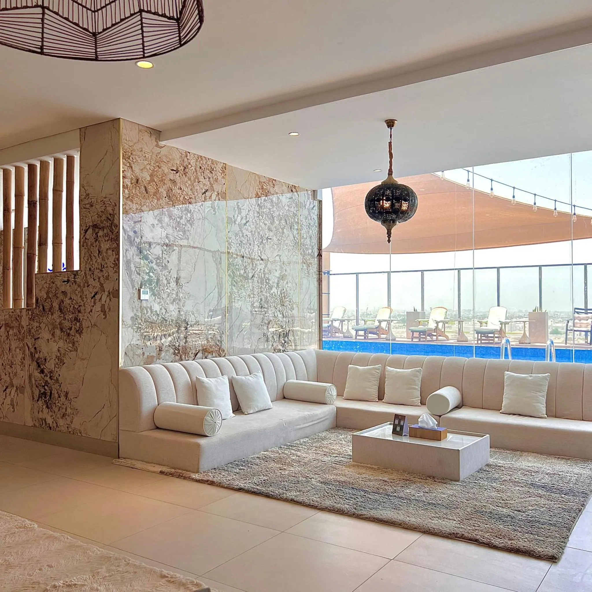 Espace de détente intérieur avec canapés et vue sur une piscine.