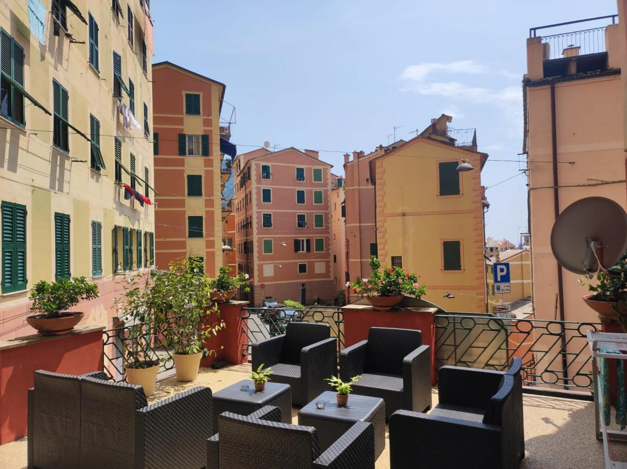 Terrasse avec mobilier de jardin et vue sur des bâtiments colorés.