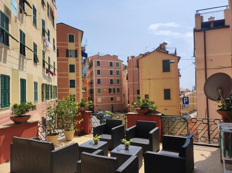 Terrasse avec mobilier de jardin et vue sur des bâtiments colorés.