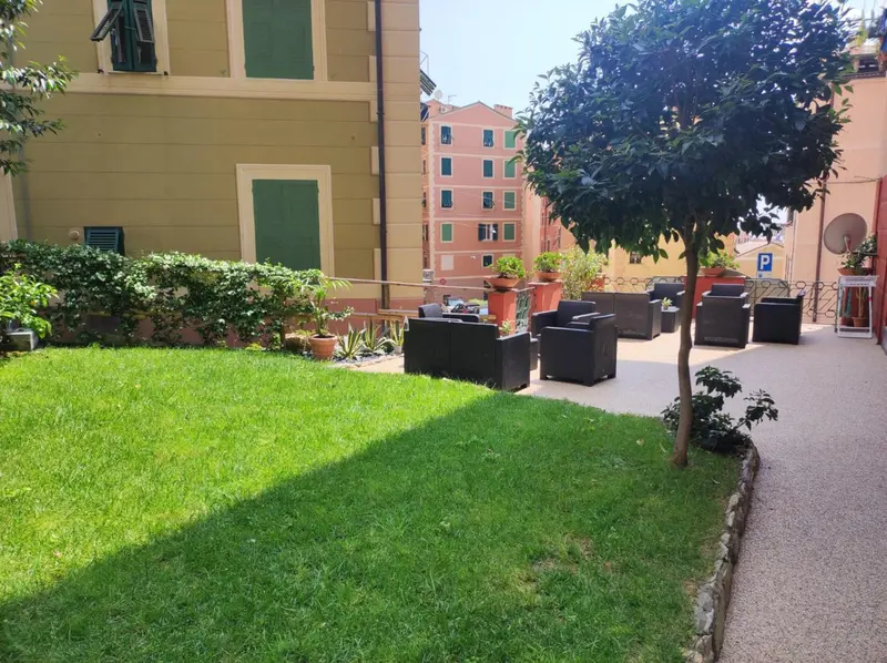 Espace extérieur aménagé avec pelouse, mobilier de jardin et végétation.