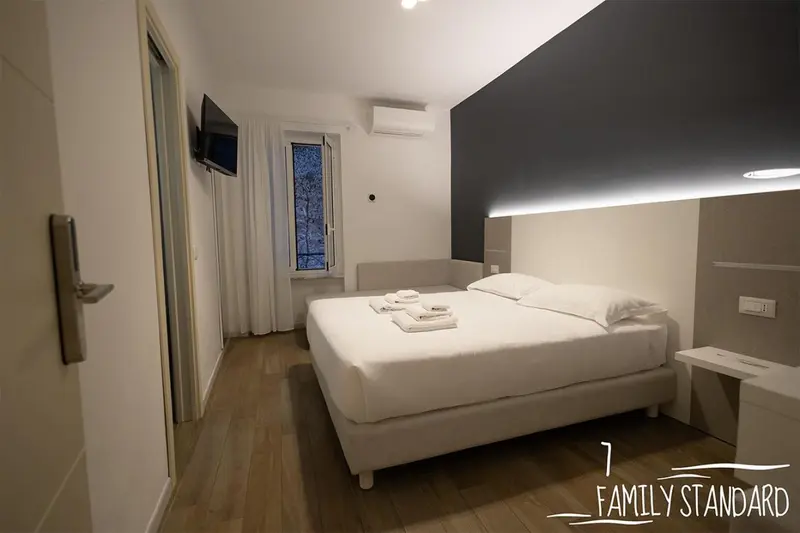 Une chambre lumineuse avec un grand lit et une télévision murale.
