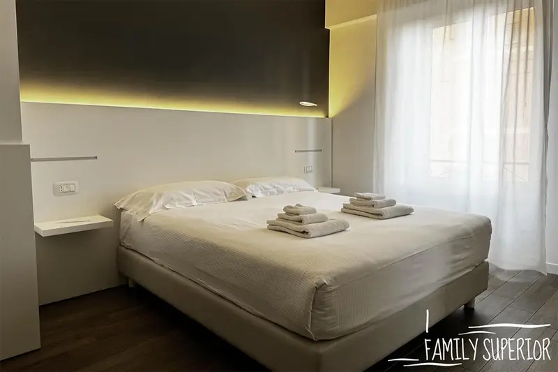 Une chambre lumineuse avec un grand lit et des rideaux blancs.