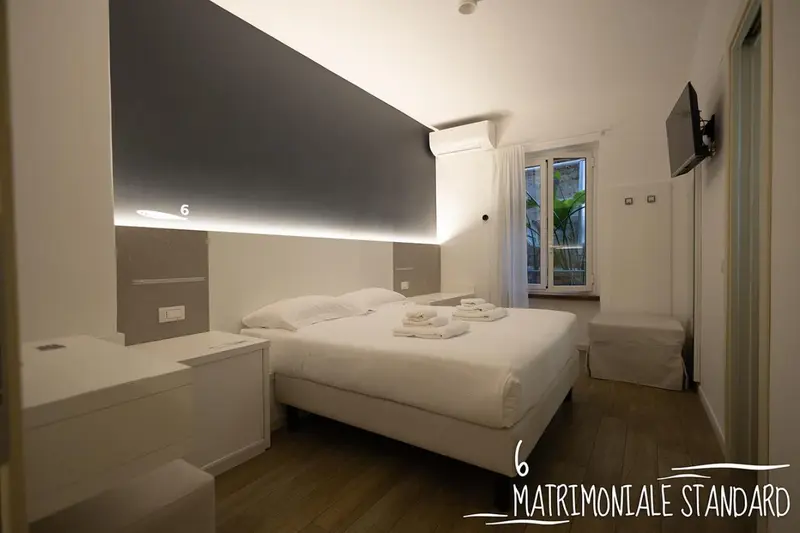 Chambre moderne avec un grand lit et un éclairage indirect.