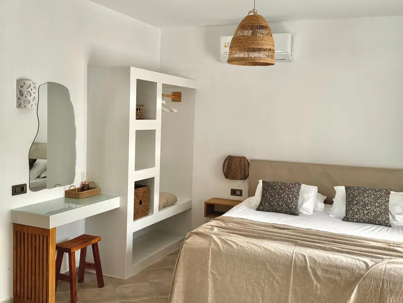 Une chambre lumineuse avec un lit fait et un espace coiffure.