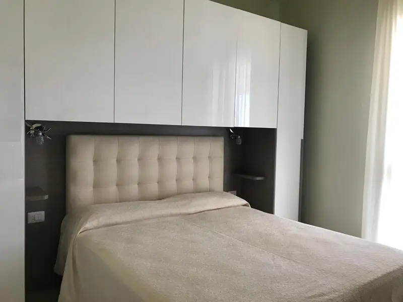 Une chambre à coucher avec un grand lit et une tête de lit rembourrée.