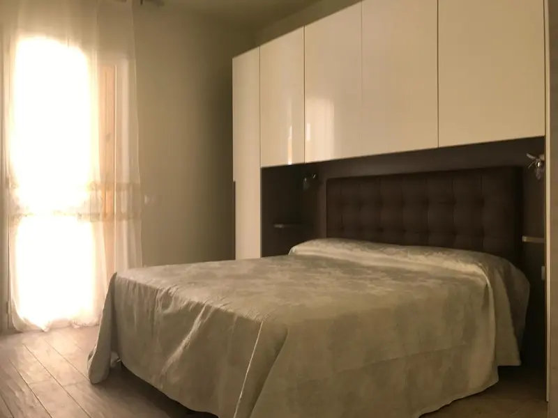 Une chambre lumineuse avec un grand lit recouvert d'une couverture.