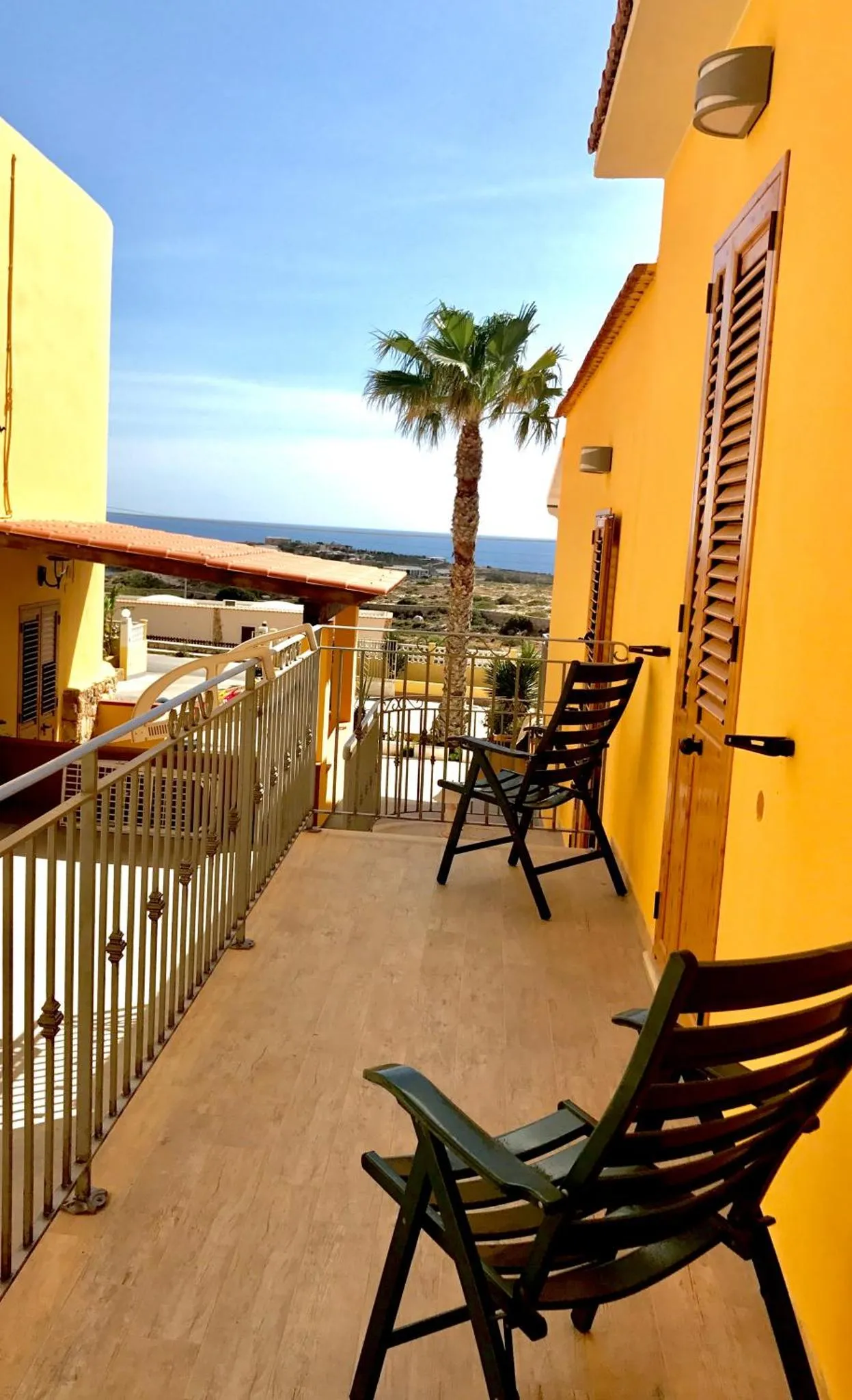 Terrasse avec mobilier d'extérieur et vue sur la mer.