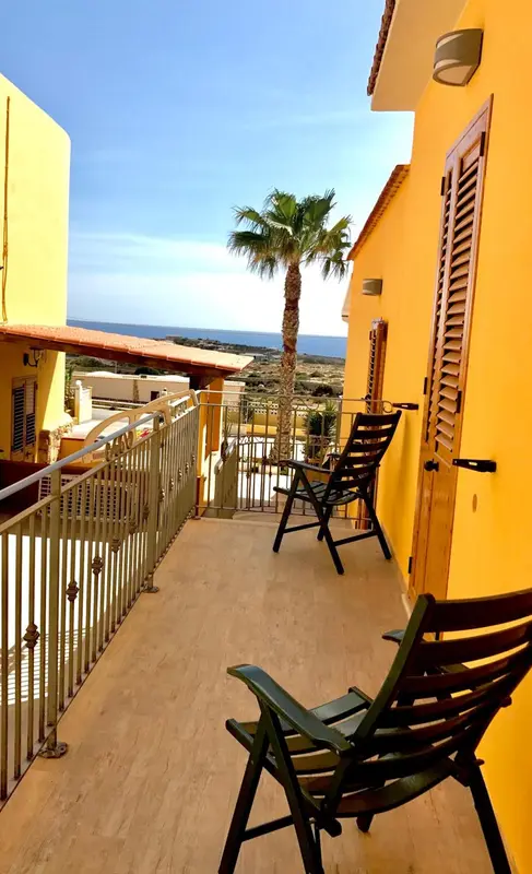 Terrasse avec mobilier d'extérieur et vue sur la mer.