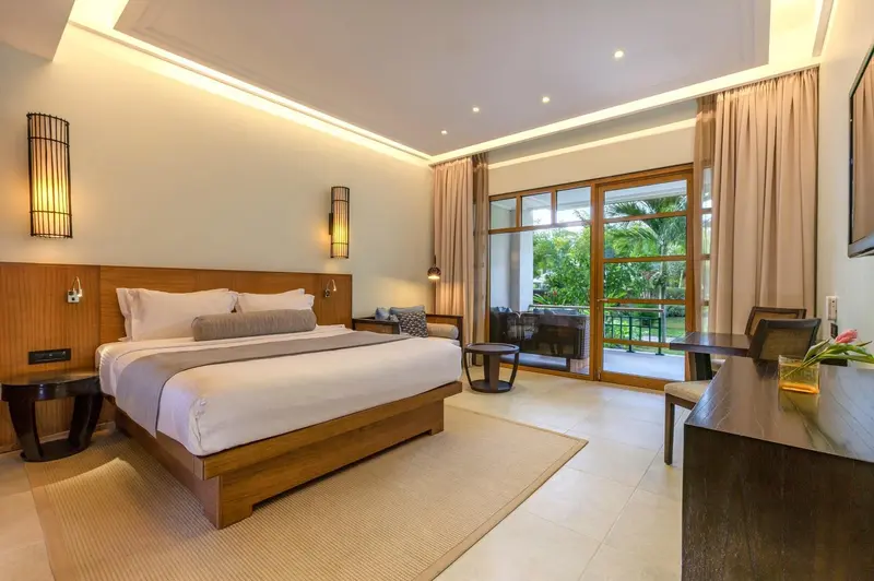 Une chambre lumineuse avec un grand lit et un accès à une terrasse.