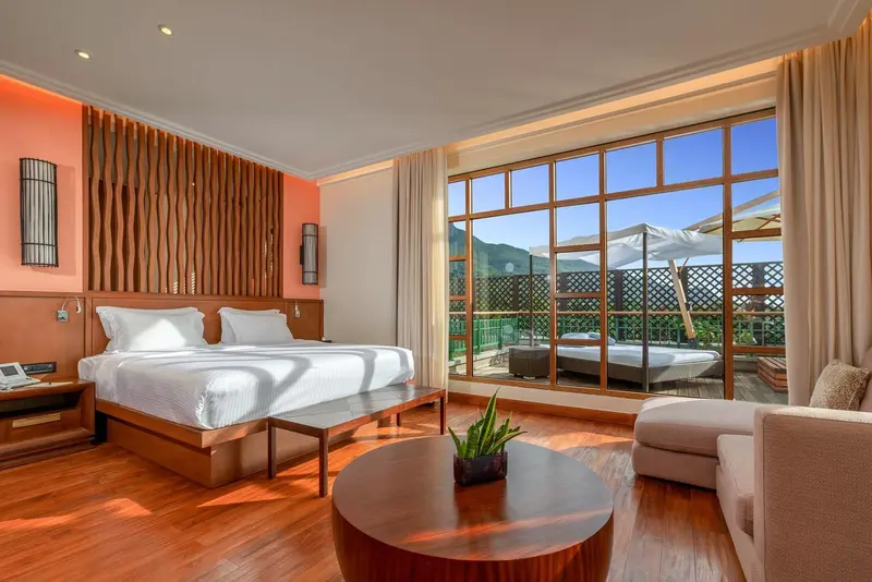 Une chambre lumineuse avec un grand lit et une vue sur une terrasse.