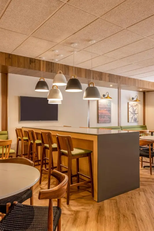 Un bar avec des tabourets et un comptoir en bois.