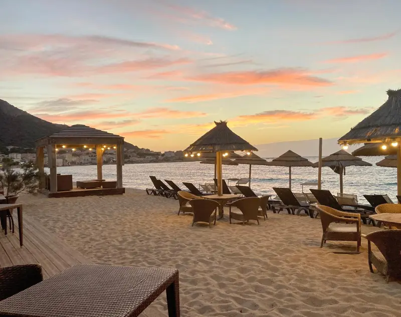 Plages ensoleillées avec parasols et mobilier de détente au bord de la mer.