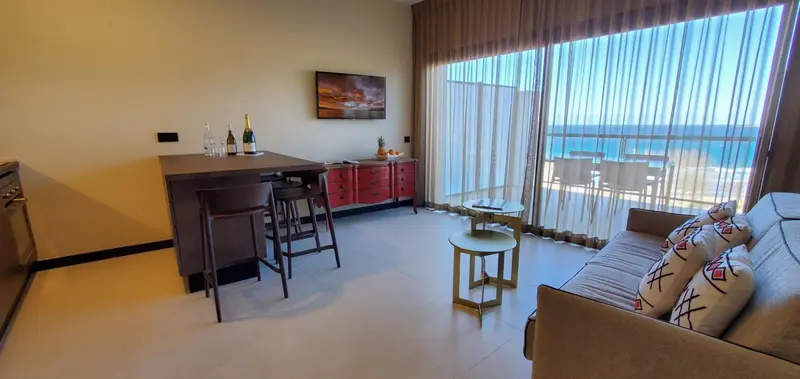 Espace de vie lumineux avec coin repas et vue sur la mer.