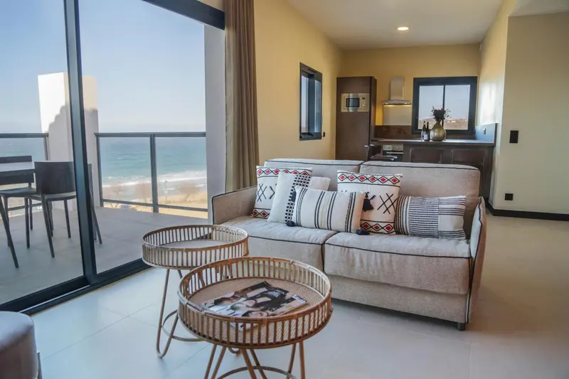 Un salon lumineux s'ouvre sur une terrasse avec vue sur la mer.