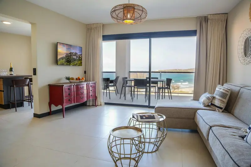 Un salon lumineux s'ouvre sur une terrasse avec vue sur la mer.