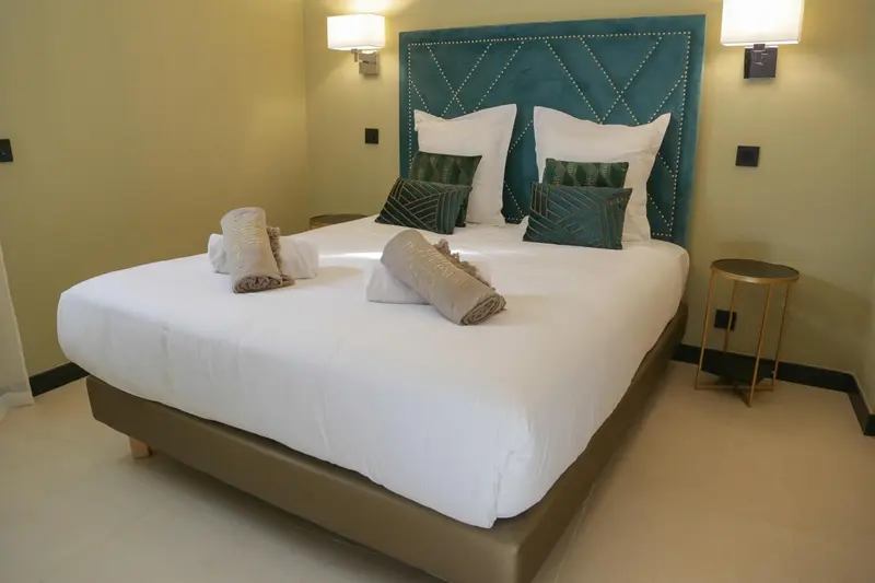 Un lit double est soigneusement fait dans une chambre décorée de couleurs vives.