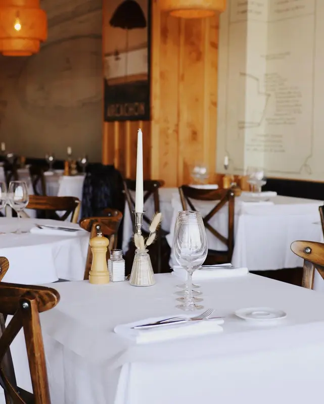 Une table dressée dans une salle lumineuse avec des chaises en bois.