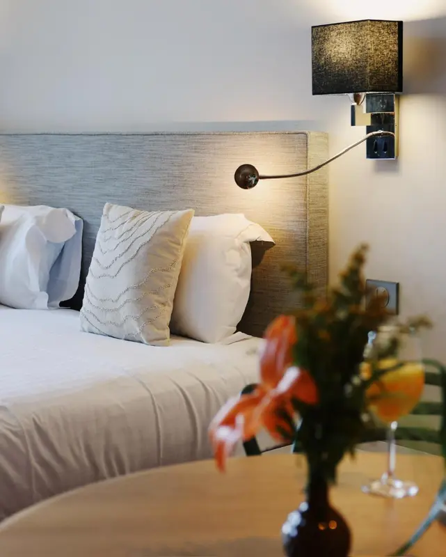 Un lit confortable avec des oreillers moelleux et une lampe de chevet.