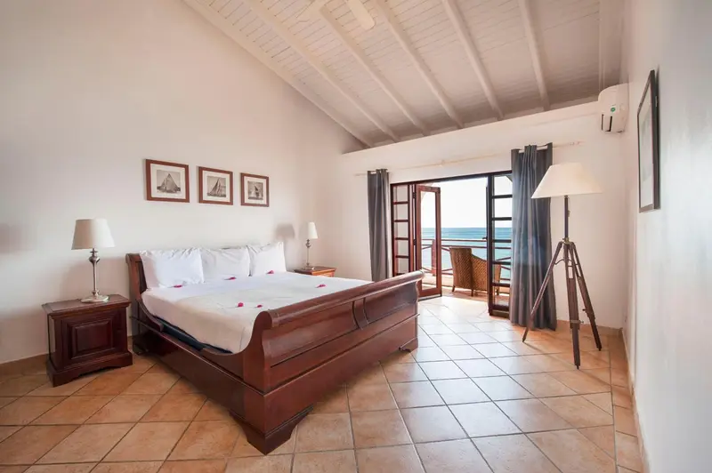 Une chambre lumineuse avec un grand lit et une vue sur la mer.