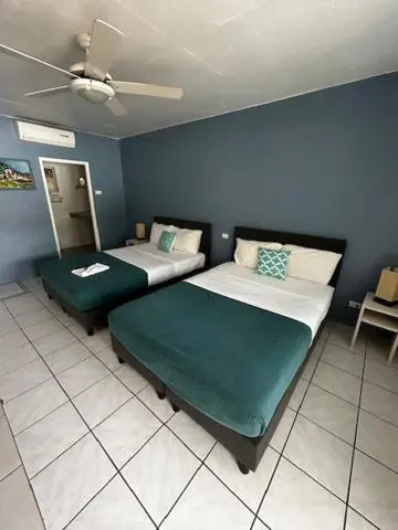 Une chambre avec deux lits simples et un accès à une salle de bain.