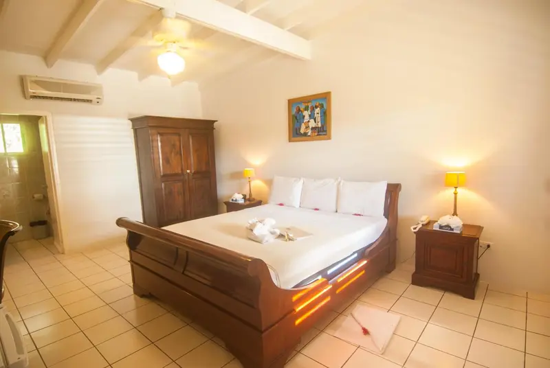 Une chambre lumineuse avec un grand lit à baldaquin et une décoration soignée.