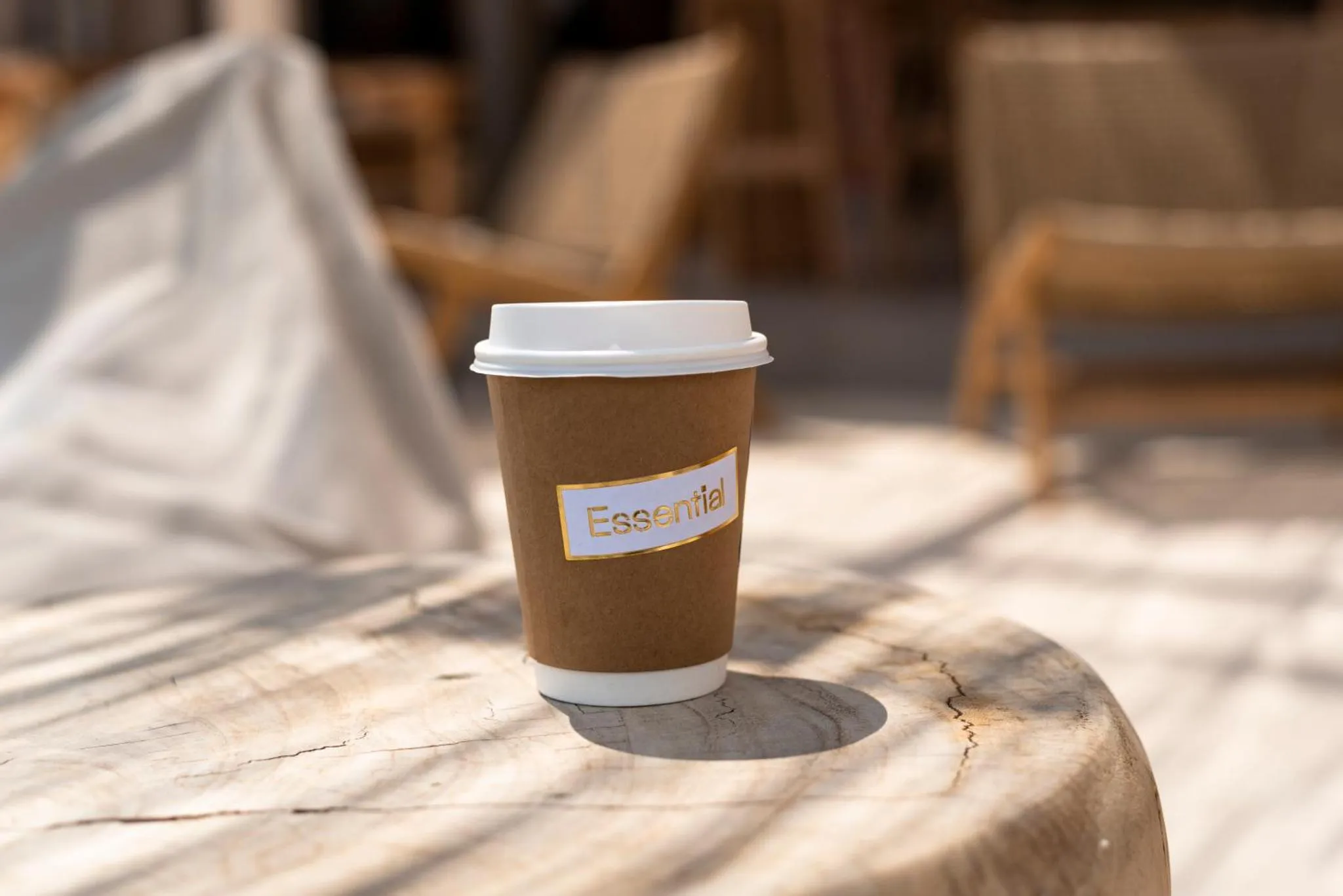 Un café à emporter sur une table en bois.