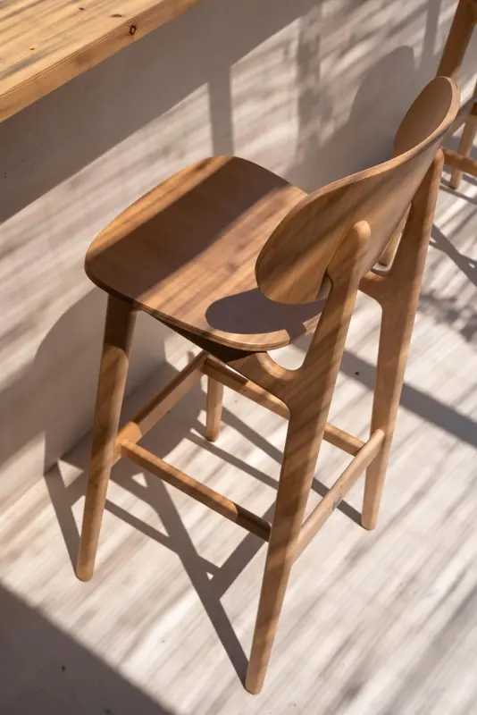Chaises en bois clair disposées sur une terrasse ensoleillée.