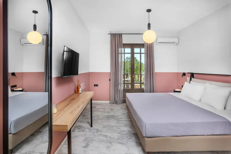 Une chambre lumineuse avec un lit double et un bureau.