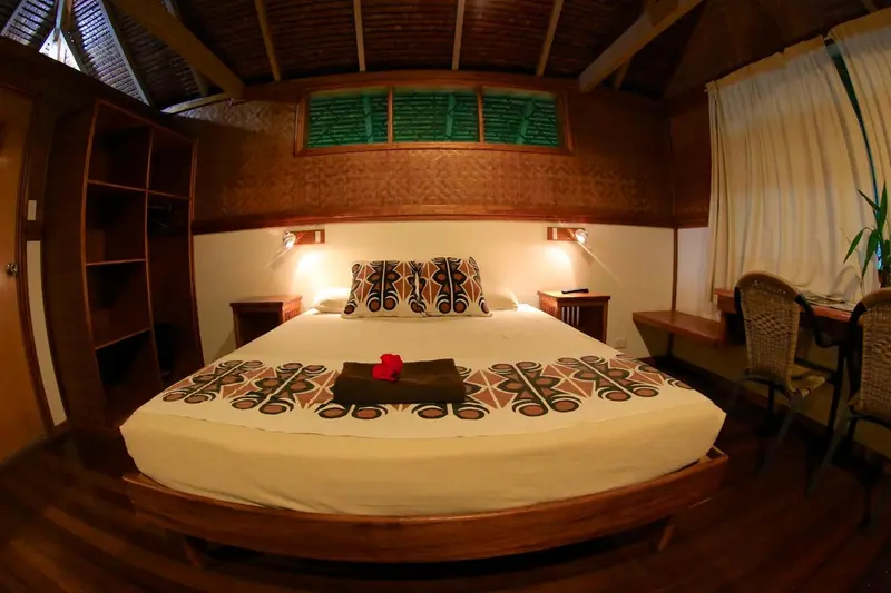 Une chambre avec un grand lit recouvert d'une courtepointe décorative et d'oreillers.