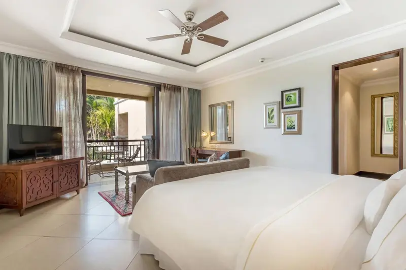 Une chambre lumineuse avec un lit king-size et un accès à une terrasse.
