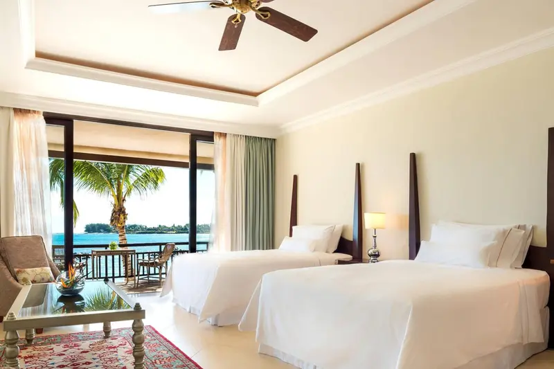 Chambre lumineuse avec vue sur la mer et un coin salon.