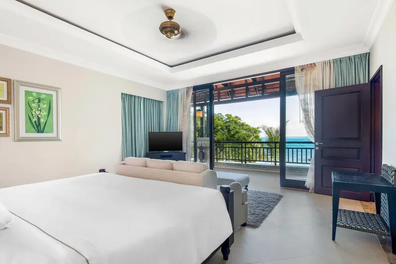 Une chambre lumineuse avec un grand lit et un canapé donnant sur une vue sur la mer.