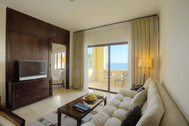 Espace de détente lumineux avec canapé et vue sur la mer.
