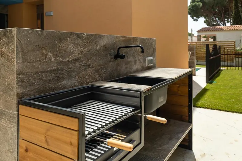 Un espace barbecue extérieur avec un plan de travail et un évier.