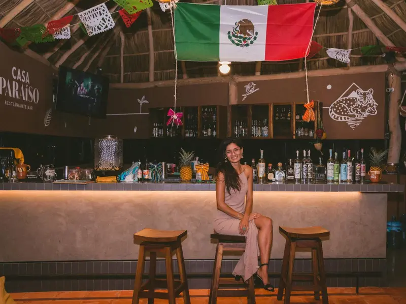 Un bar en plein air avec une serveuse souriante.