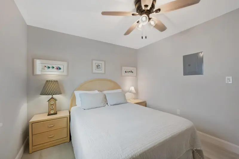 Une chambre lumineuse avec un lit double et des tables de chevet.