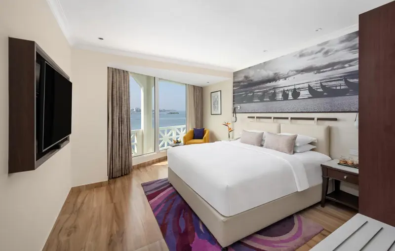 Une chambre lumineuse avec un grand lit et une vue sur la mer.