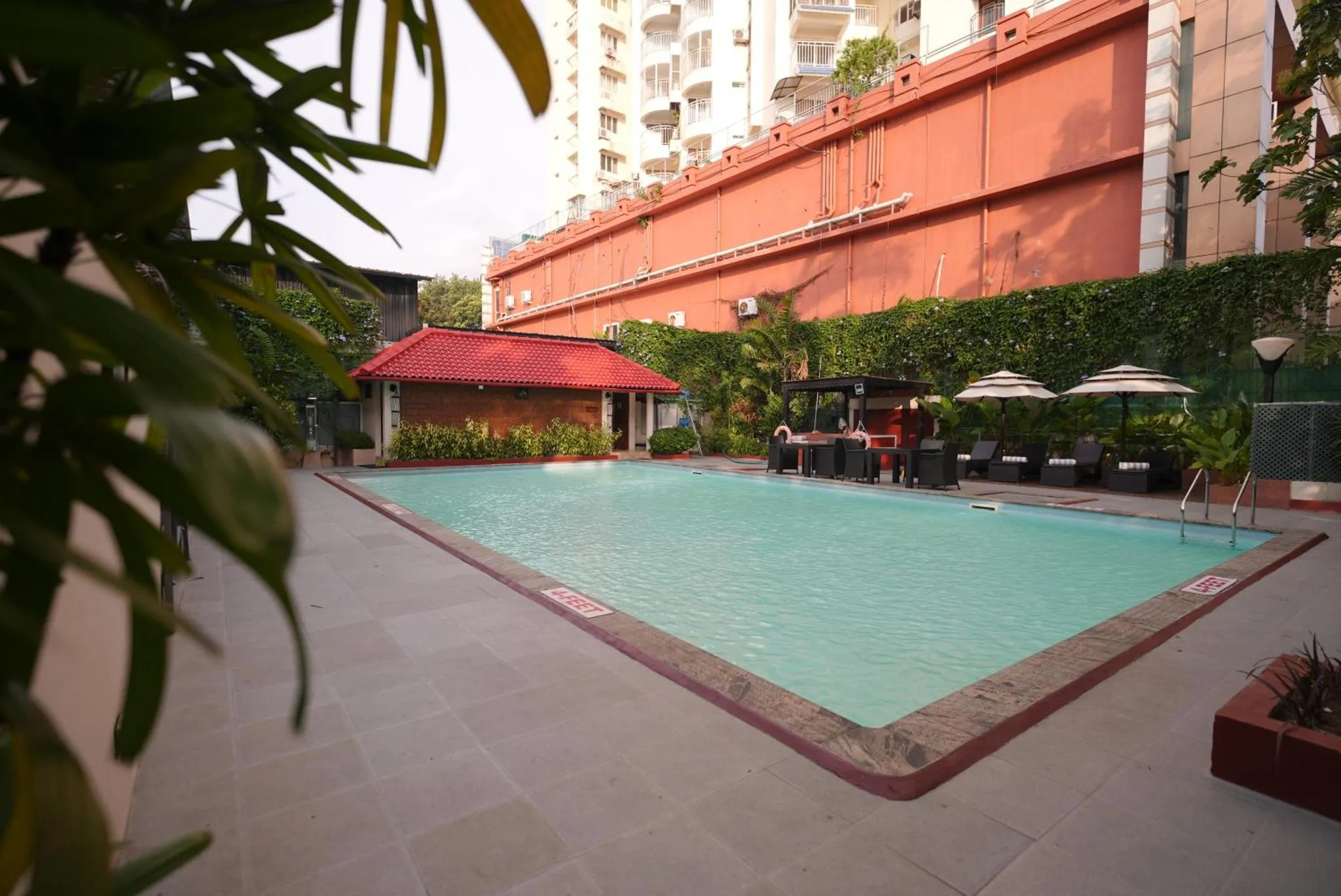 Une piscine rectangulaire turquoise bordée d'une terrasse carrelée.