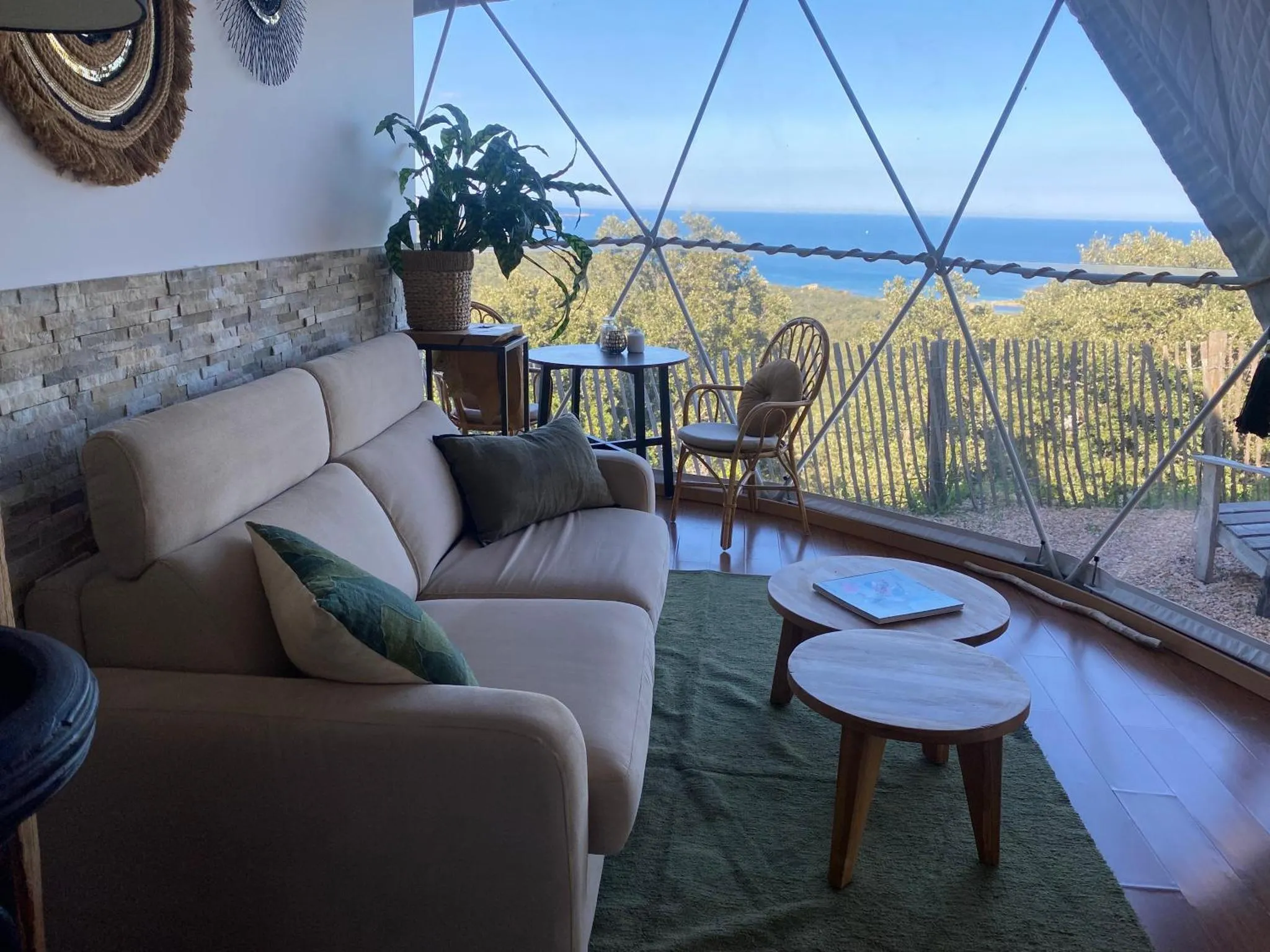 Un espace de détente intérieur avec canapé, table basse et vue sur la mer.