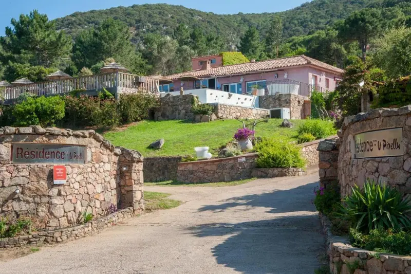 Vue d'une résidence avec des bâtiments aux toits en tuiles et une végétation luxuriante.