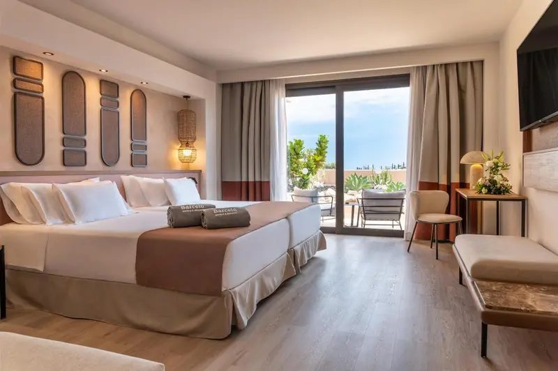 Une chambre lumineuse avec un grand lit et un accès à une terrasse.