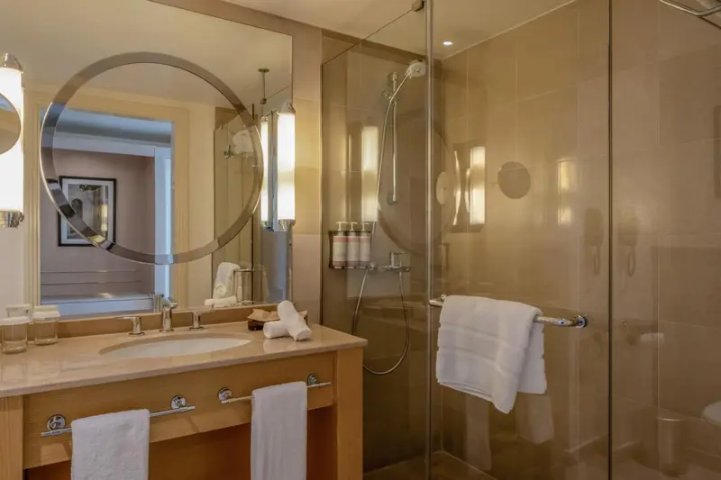 Une salle de bain lumineuse avec une douche à l'italienne et un grand miroir.