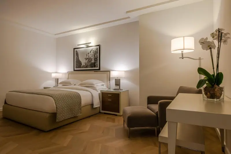 Une chambre lumineuse avec un grand lit et un coin salon.