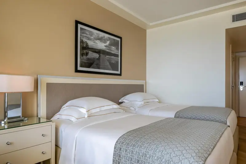 Une chambre avec deux lits simples et une décoration sobre.